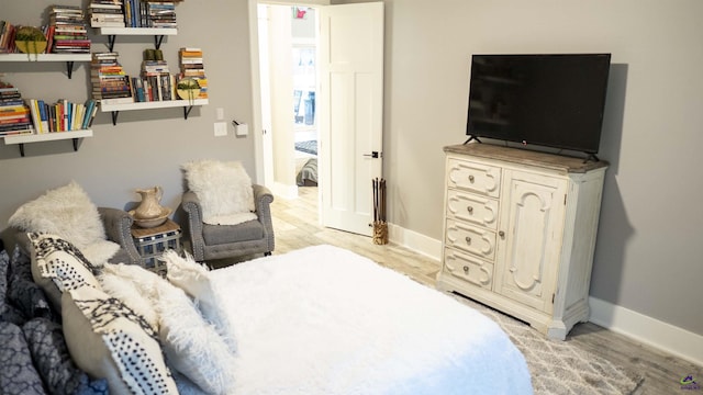 bedroom featuring light wood finished floors and baseboards