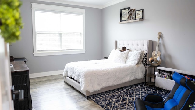 bedroom featuring crown molding, wood finished floors, and baseboards