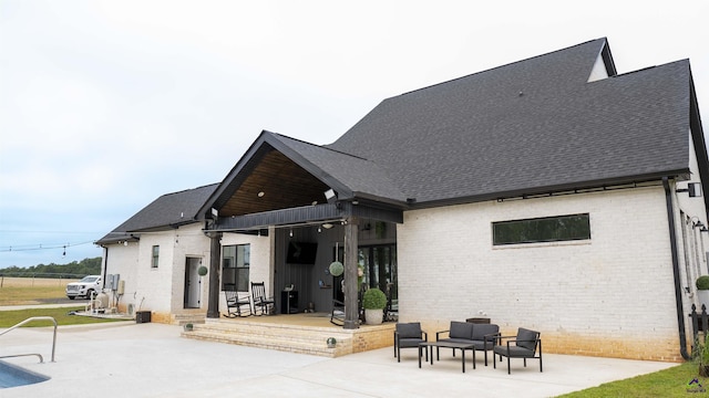 back of property with a patio, brick siding, and a shingled roof