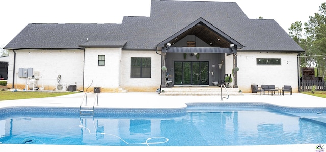 outdoor pool with a patio, fence, entry steps, and central AC unit
