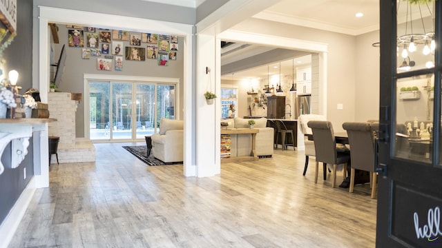 interior space with light wood finished floors, crown molding, and recessed lighting