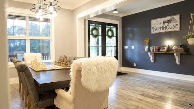 dining room with baseboards, a chandelier, crown molding, and wood finished floors