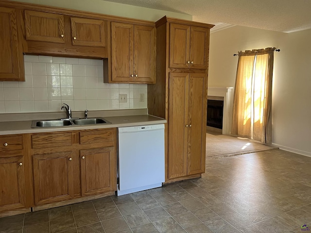 113 Easy St, Dublin, GA 31021 - kitchen with white dishwasher, a sink, brown cabinetry, tasteful backsplash, and a fireplace