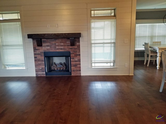 living area with a fireplace, baseboards, and wood finished floors