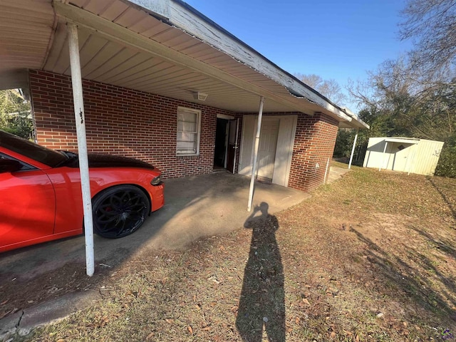 318 Vick St, Albany, GA 31705 - view of home's exterior featuring brick siding, an outbuilding, an attached carport, and a storage unit