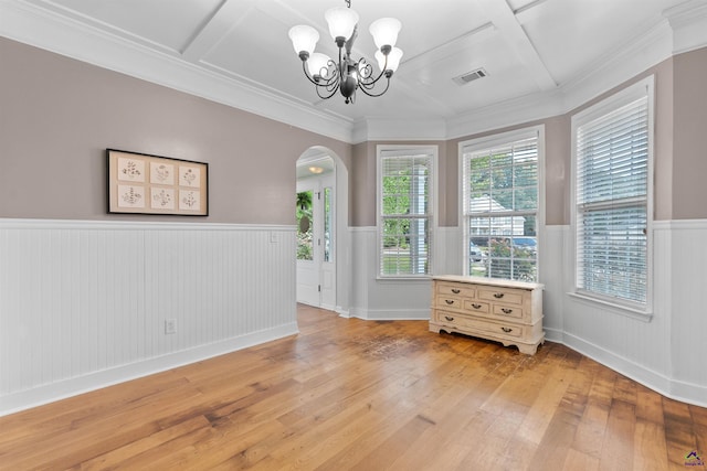 unfurnished room with an inviting chandelier, visible vents, a wainscoted wall, arched walkways, and light wood-type flooring