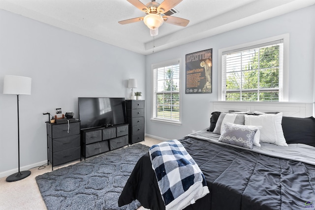 carpeted bedroom with visible vents, baseboards, and a ceiling fan