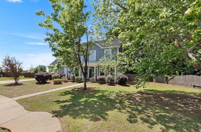 view of front of home with a front lawn and fence