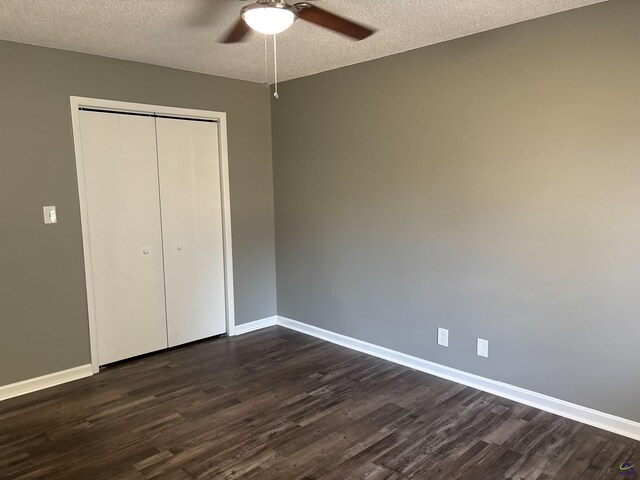 4211 Cyndy Jo Cir, Macon, GA 31216 - unfurnished bedroom featuring dark wood-type flooring, baseboards, a closet, a textured ceiling, and a ceiling fan