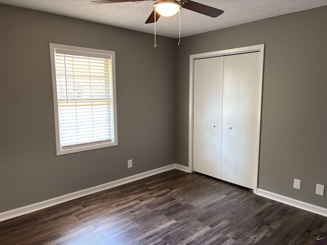 4211 Cyndy Jo Cir, Macon, GA 31216 - unfurnished bedroom featuring dark wood-style floors, a closet, a textured ceiling, baseboards, and ceiling fan