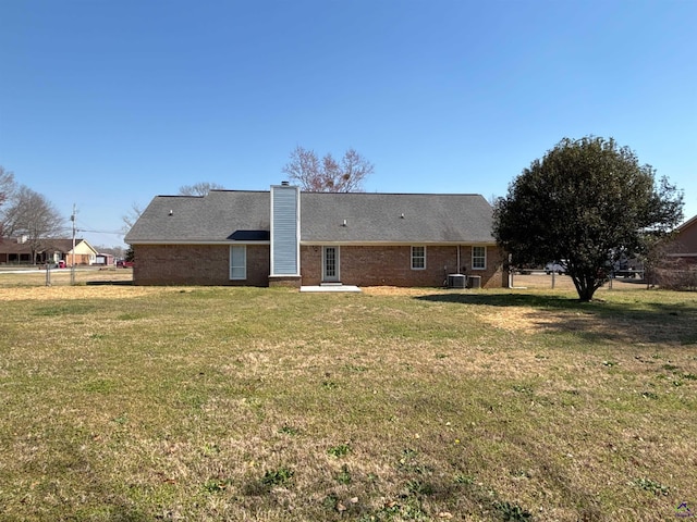4211 Cyndy Jo Cir, Macon, GA 31216 - back of house featuring a chimney, a lawn, brick siding, and central AC