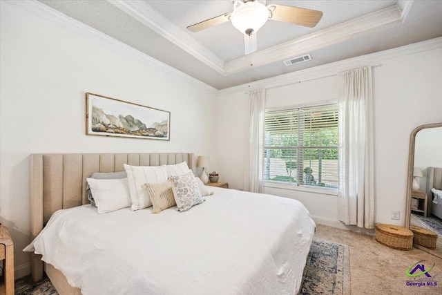 carpeted bedroom featuring ornamental molding, a raised ceiling, and ceiling fan