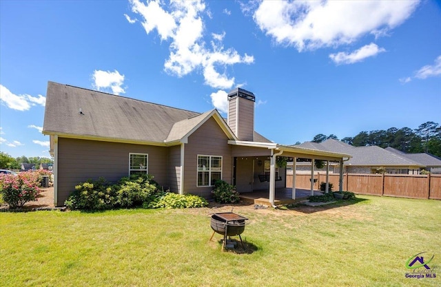 back of house with an outdoor fire pit, a chimney, and a patio