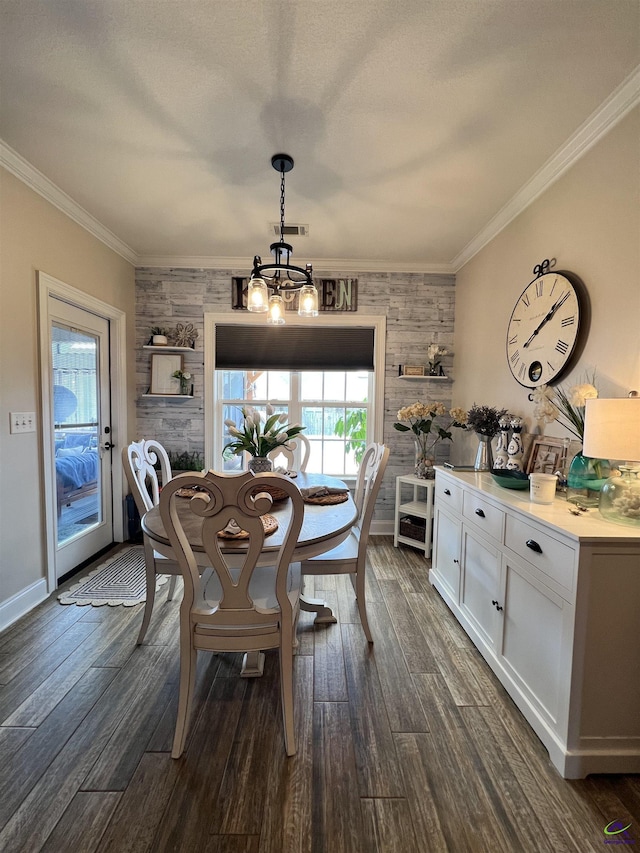 dining area with a chandelier, crown molding, dark wood-type flooring, wood walls, and baseboards