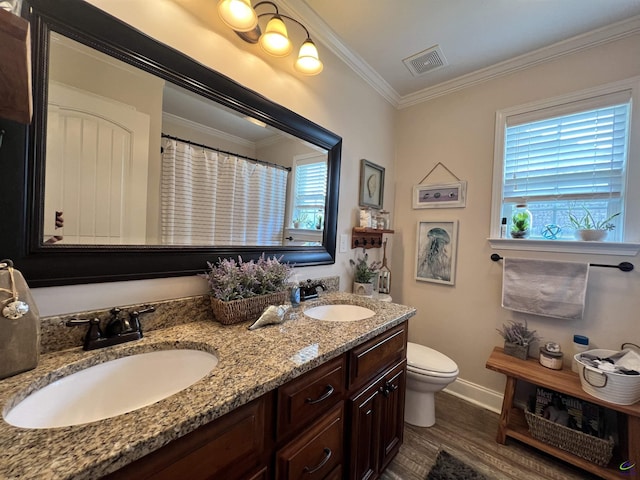 bathroom featuring plenty of natural light, wood finished floors, toilet, baseboards, and crown molding