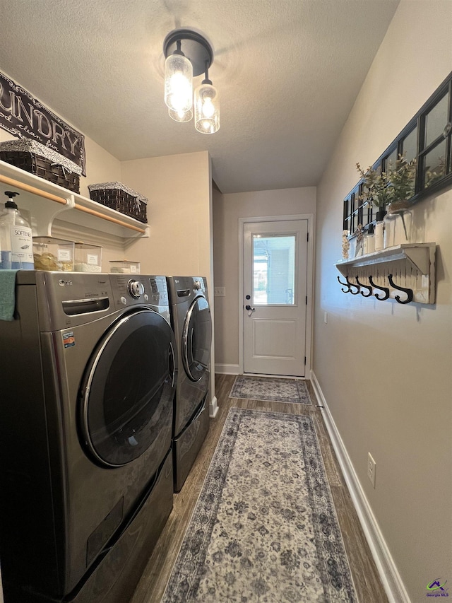 laundry room featuring independent washer and dryer, wood finished floors, a textured ceiling, and baseboards