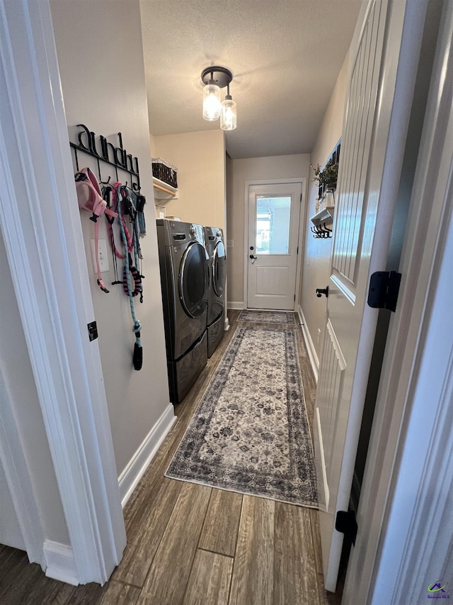 laundry room featuring independent washer and dryer, wood finished floors, baseboards, and a textured ceiling