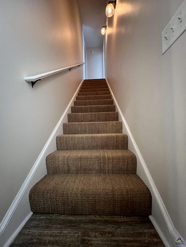 staircase with wood finished floors and baseboards