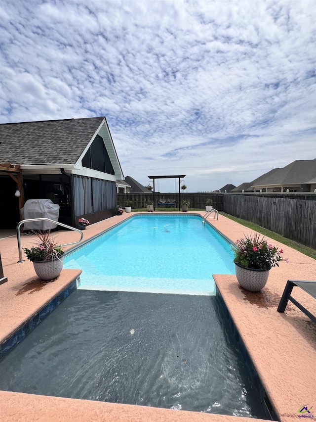 view of swimming pool with a fenced backyard, a grill, and a patio