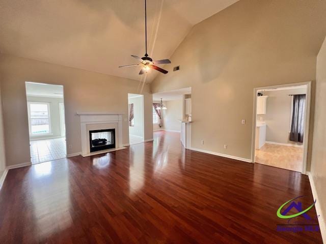 505 Scarlett Dr, Warner Robins, GA 31088 - unfurnished living room featuring wood finished floors, a ceiling fan, a fireplace, baseboards, and high vaulted ceiling