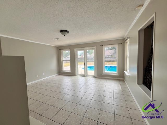 505 Scarlett Dr, Warner Robins, GA 31088 - spare room with crown molding, a textured ceiling, light tile patterned flooring, and baseboards