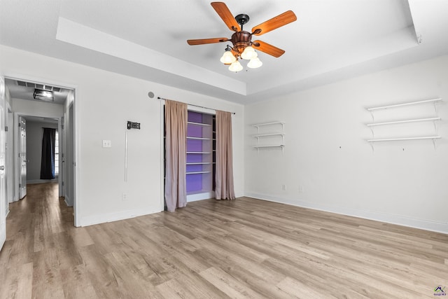 465 Pitts Rd, Hawkinsville, GA 31036 - unfurnished bedroom with light wood-style flooring, a raised ceiling, baseboards, and a ceiling fan