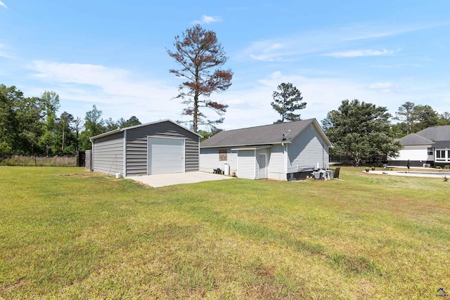 465 Pitts Rd, Hawkinsville, GA 31036 - back of house featuring a detached garage, an outdoor structure, and a lawn