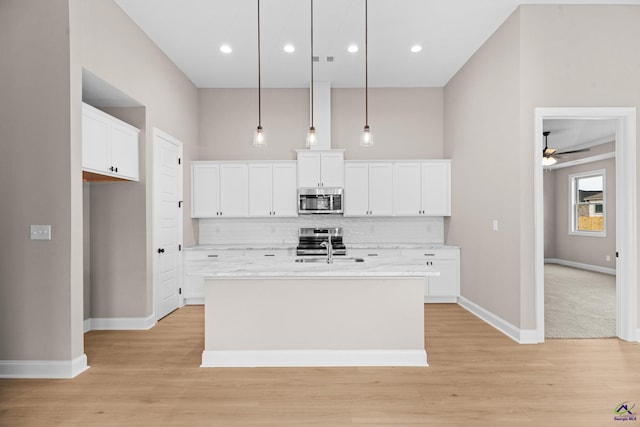 kitchen with appliances with stainless steel finishes, backsplash, light wood-type flooring, baseboards, and recessed lighting