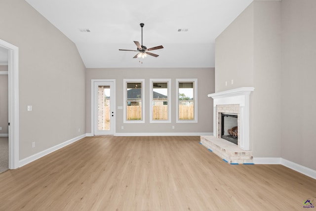 unfurnished living room featuring ceiling fan, light wood finished floors, baseboards, a brick fireplace, and vaulted ceiling