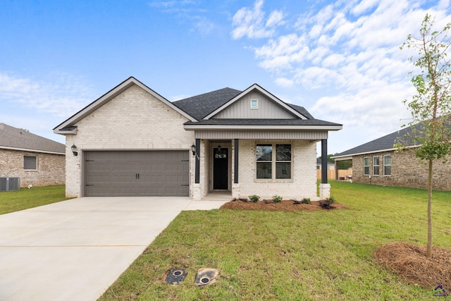 view of front of house with brick siding, an attached garage, a front yard, driveway, and central AC unit