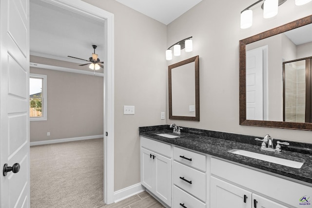 full bathroom featuring baseboards, ceiling fan, a shower with door, and double vanity