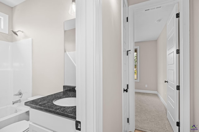 full bathroom featuring vanity, toilet,  shower combination, and baseboards