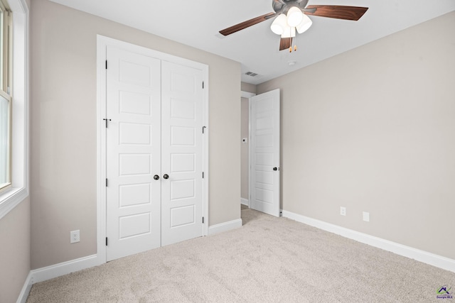 unfurnished bedroom featuring a closet, carpet flooring, baseboards, and ceiling fan