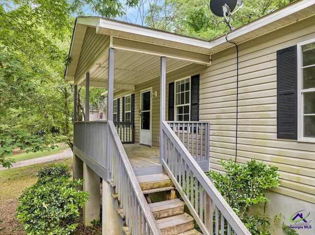 deck featuring covered porch and stairway