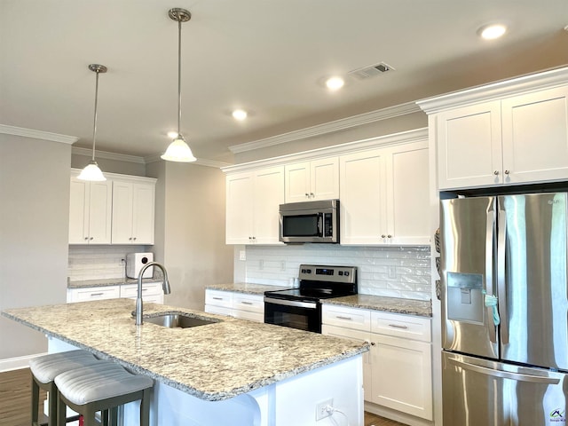 kitchen with appliances with stainless steel finishes, a sink, an island with sink, a kitchen breakfast bar, and crown molding