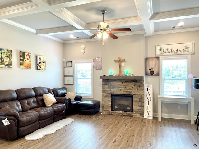 living room featuring coffered ceiling, ceiling fan, wood finished floors, a fireplace, and crown molding