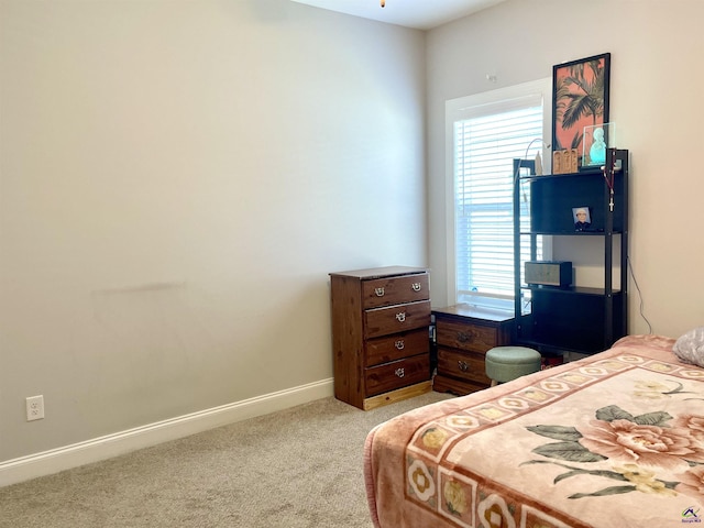 bedroom with light colored carpet and baseboards
