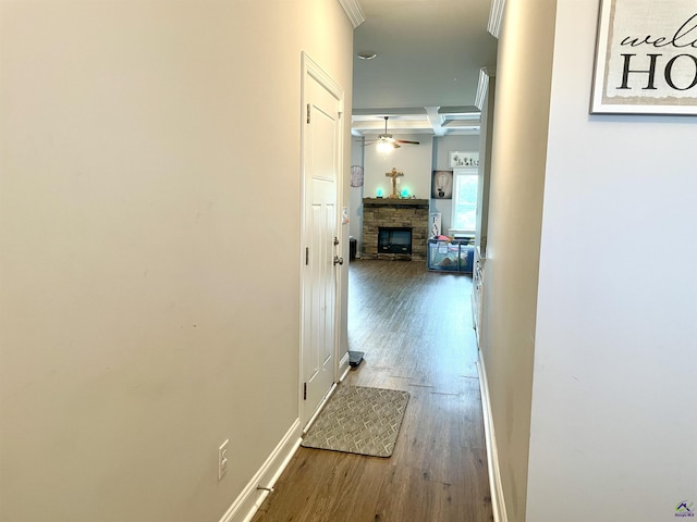 hall with ornamental molding, wood finished floors, and baseboards