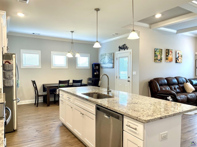 kitchen featuring a sink, stainless steel appliances, open floor plan, light wood finished floors, and ornamental molding