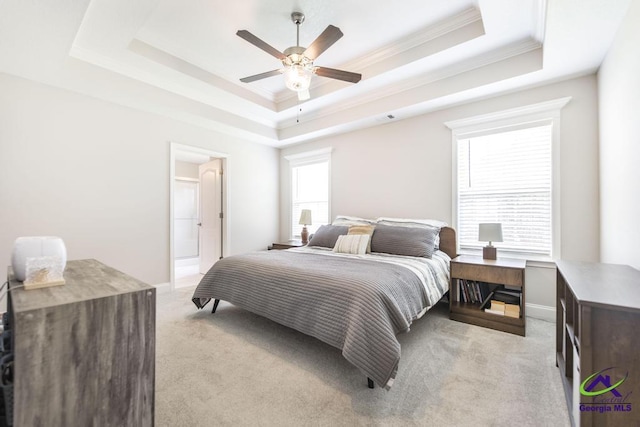 bedroom with light carpet, a raised ceiling, ornamental molding, baseboards, and a ceiling fan