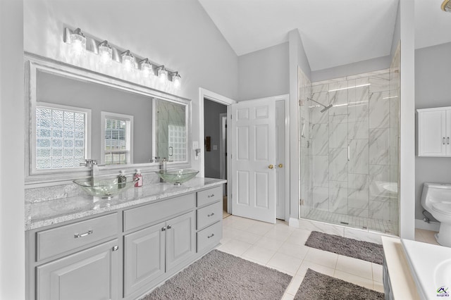 bathroom featuring toilet, a stall shower, vanity, lofted ceiling, and tile patterned floors