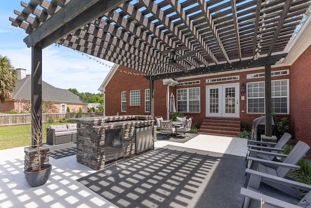 view of patio / terrace featuring entry steps, exterior kitchen, fence, and a pergola