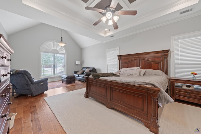 bedroom with light wood-style floors, ornamental molding, a tray ceiling, a ceiling fan, and vaulted ceiling