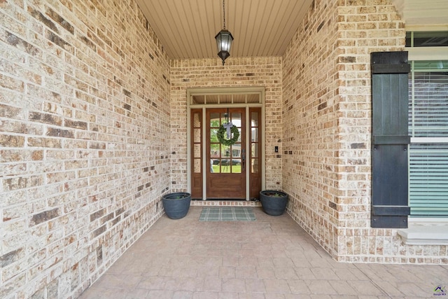 view of exterior entry featuring brick siding