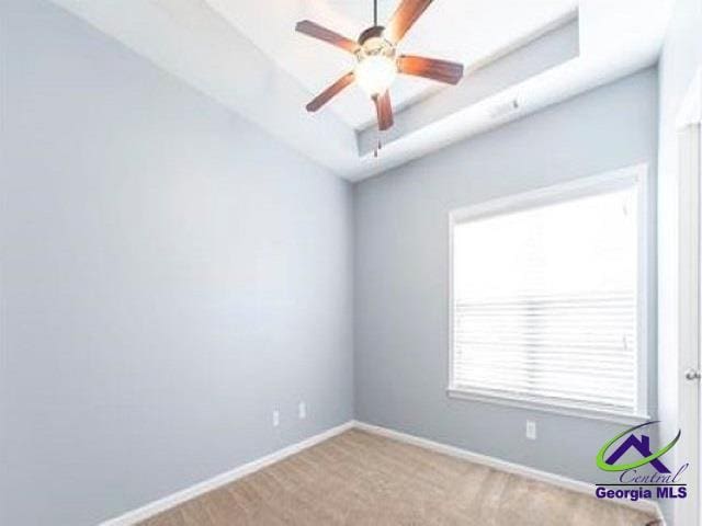 empty room featuring baseboards, ceiling fan, and carpet floors