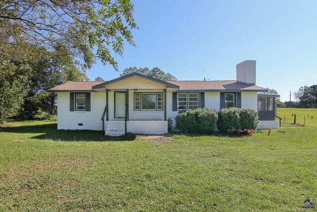 118 Wimberly Rd, Hawkinsville, GA 31036 - view of front facade featuring a front lawn, a chimney, brick siding, and crawl space