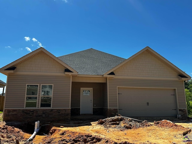 craftsman inspired home featuring an attached garage, stone siding, and a shingled roof