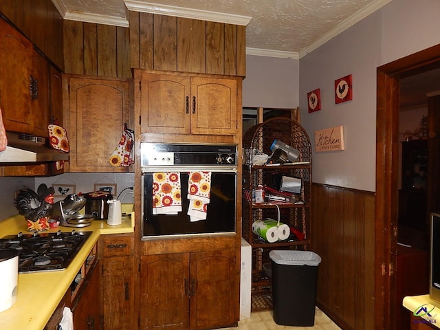 7085 US Highway 341 S, Roberta, GA 31078 - kitchen featuring black appliances, under cabinet range hood, light countertops, wainscoting, and brown cabinetry