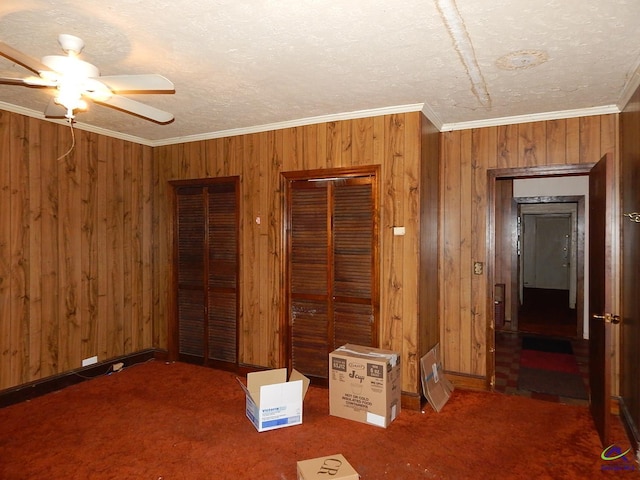 7085 US Highway 341 S, Roberta, GA 31078 - unfurnished bedroom featuring wood walls, ornamental molding, two closets, carpet flooring, and ceiling fan
