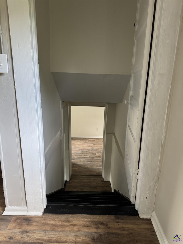stairway with wood finished floors and baseboards